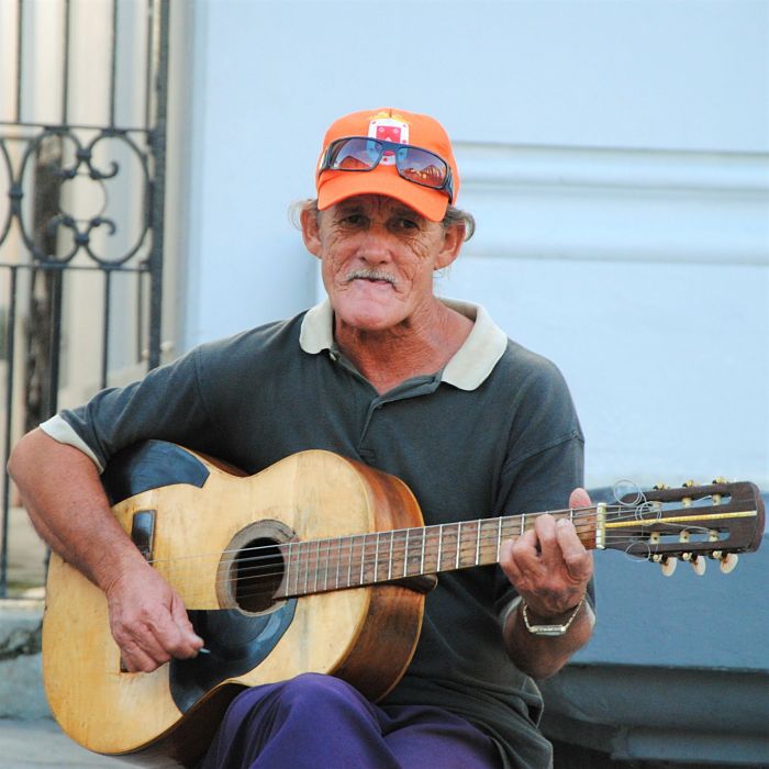 Un cubain joue de la guitare et siffle dans la rue